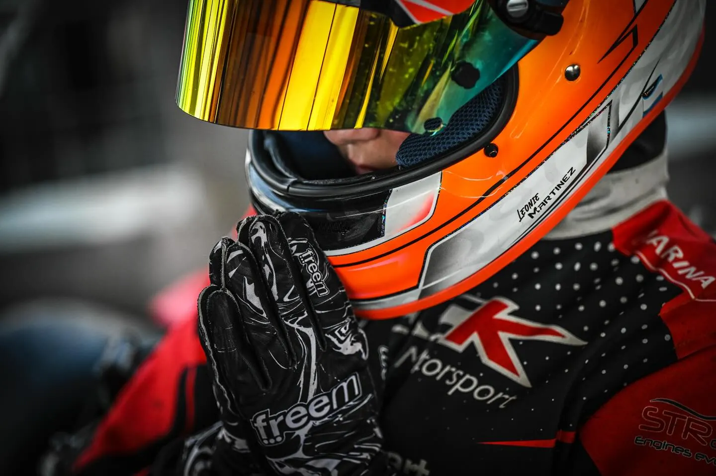 Piloto de ECK con el casco puesto y las manos juntas, concentrándose antes de salir
