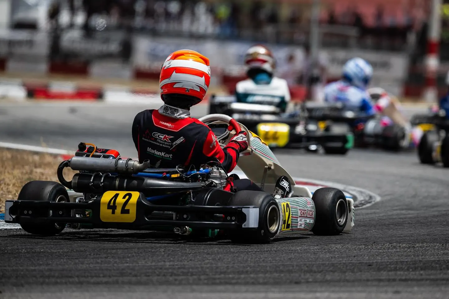 Piloto de ECK persiguiendo a un grupo de karts en carrera